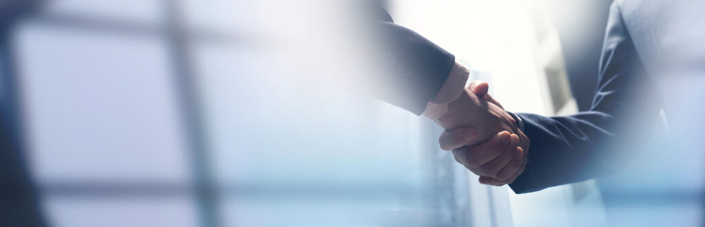 Businessmen shaking hands, representing the commercial litigation services of Milosevic & Associates in Toronto, including urgent injunctions and asset freezing.