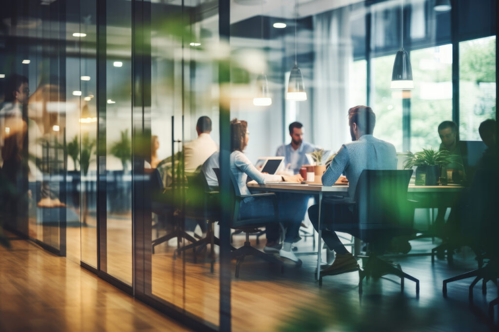 A group of work colleagues at a boardroom table as viewed through frosted glass, representing the lawyer negligence and professional liability advocacy provided by Milosevic & Associates in Toronto.