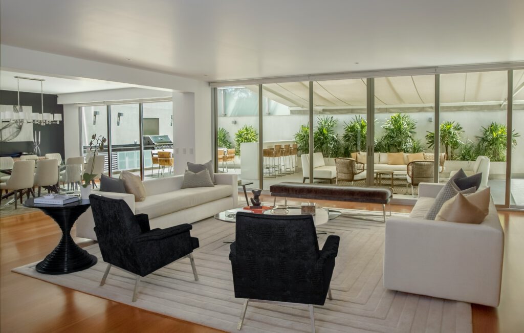A modern, open-concept living and dining room, looking out onto an outdoor patio, representing the commercial real estate litigation services provided by Milosevic & Associates in Toronto.