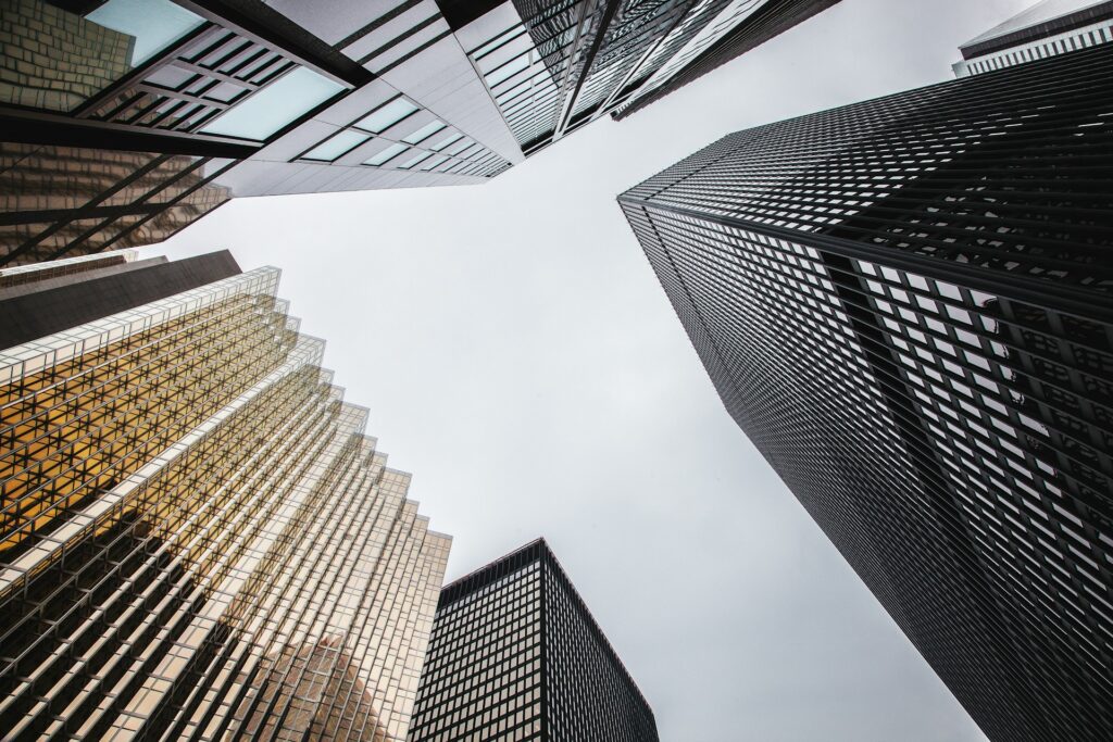 Ground-up view of the sky between skyscrapers, representing the commercial real estate litigation services provided by the Toronto business litigation lawyers in Milosevic & Associates.