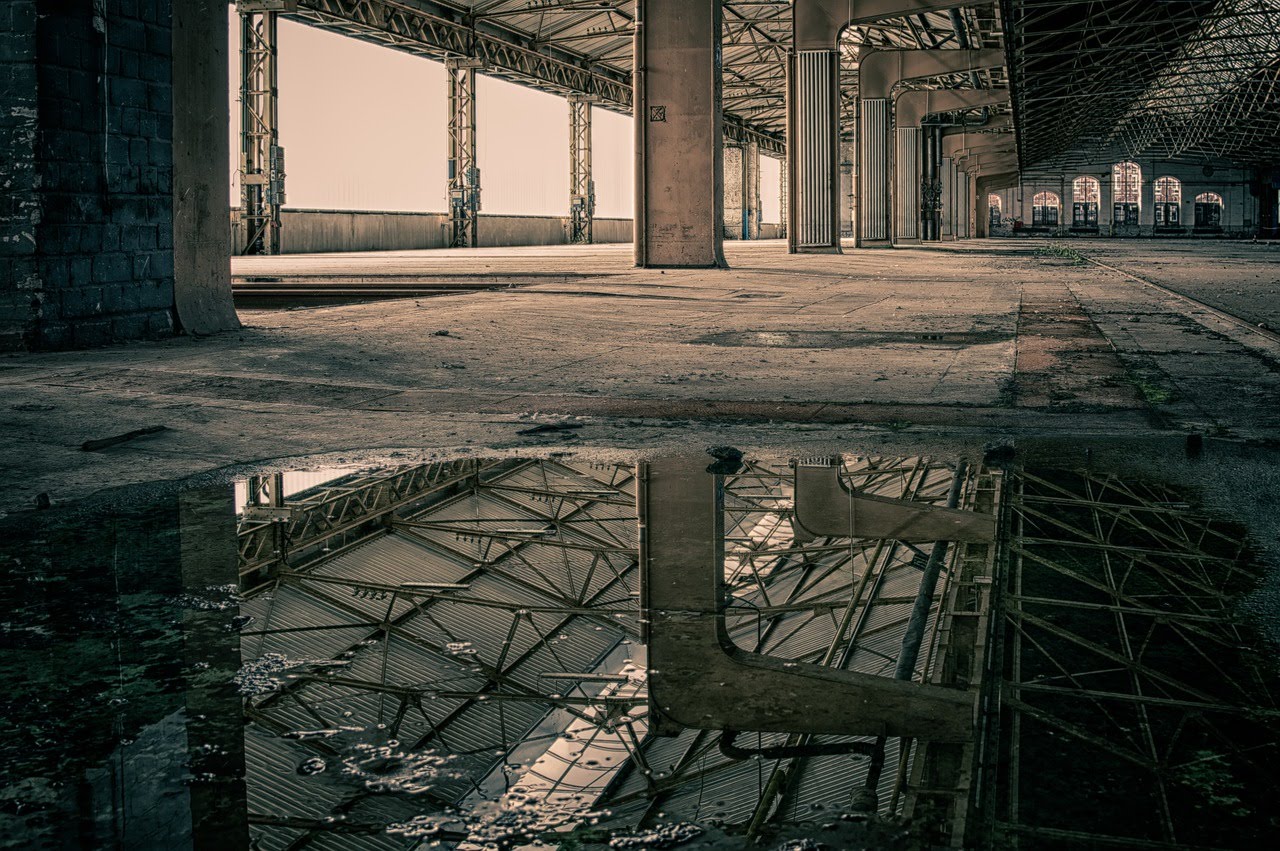 large, empty commercial space with open windows and support columns