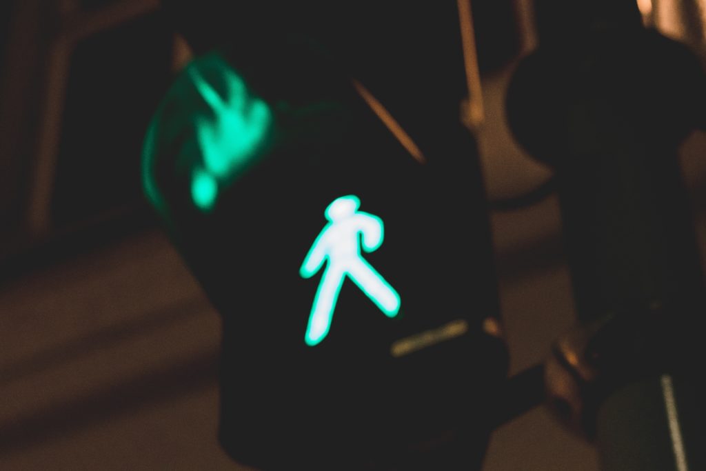 neon walk sign showing figure taking step