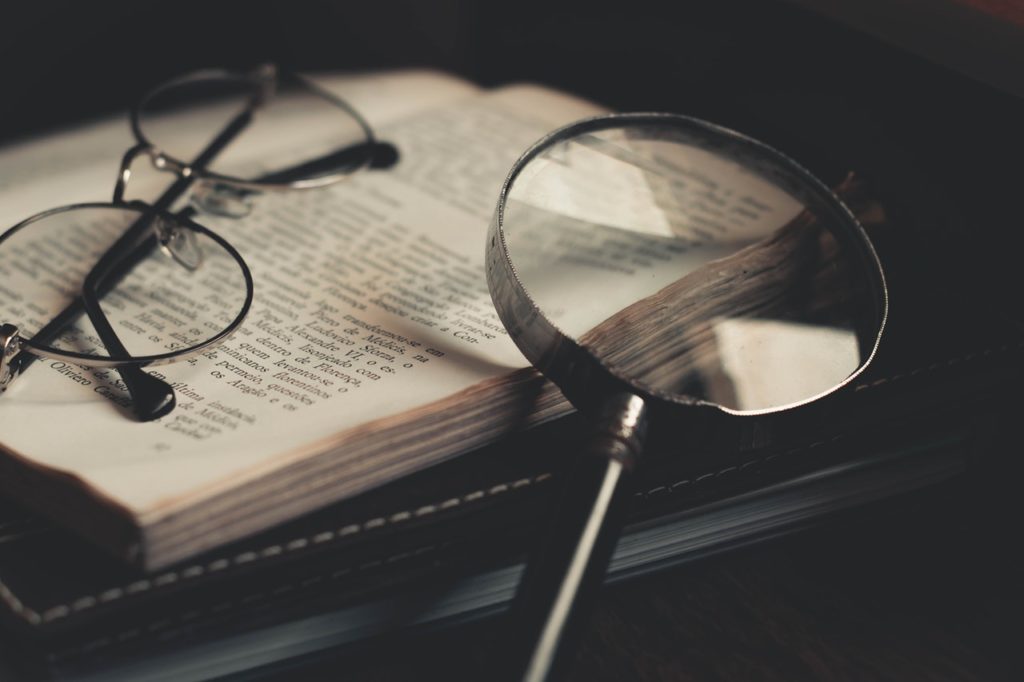 A magnifying glass on an open book, representing the search for meaning in statutory language