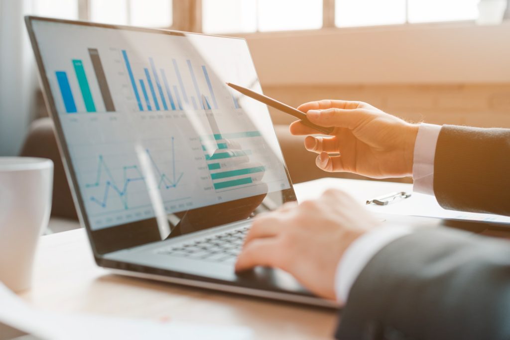 A person looking at graphs on a computer screen, representing a fiduciary role where constructive fraud could occur