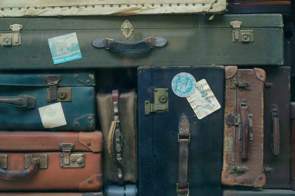 Stacks of vintage suitcases, representing a travel agency fraud case involving funds received for selling airline tickets