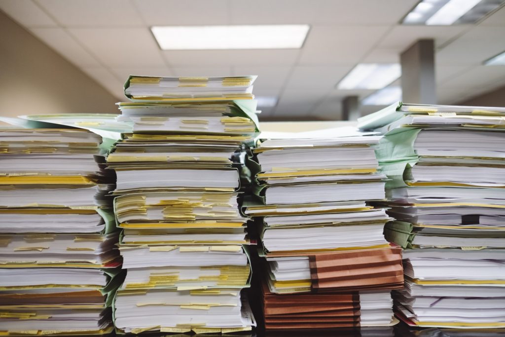 Stacks of file folders on a table representing an appeal heard remotely in writing