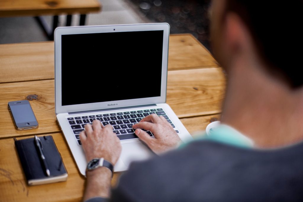 A man on a laptop representing how online reviews of professionals can result in a defamation claim