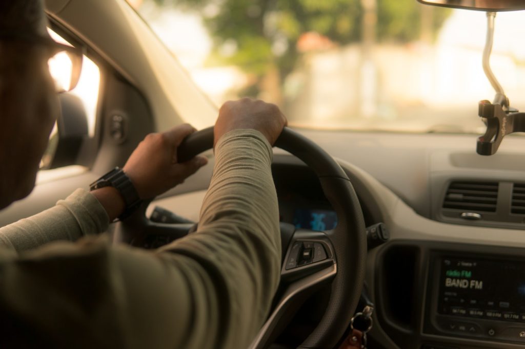 A man driving a car representing a new class action against Uber