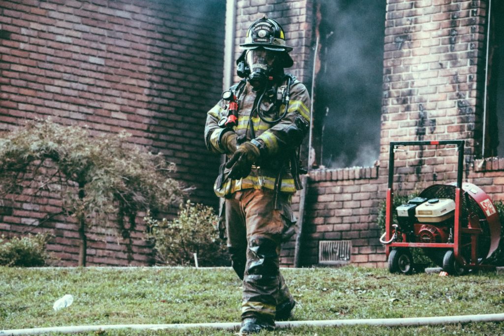 Firefighter leaving a burned out building.