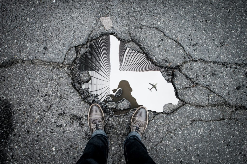 A person standing over a pothole