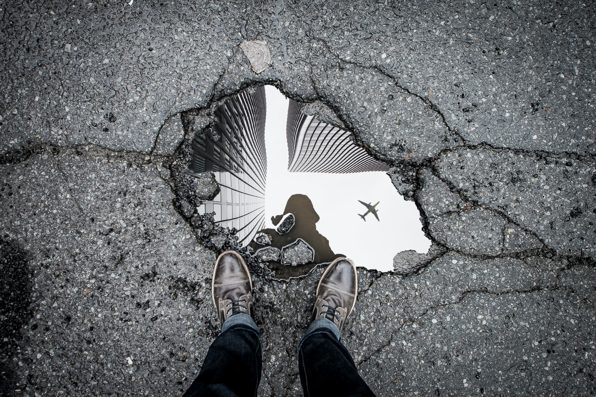 A person standing over a pothole