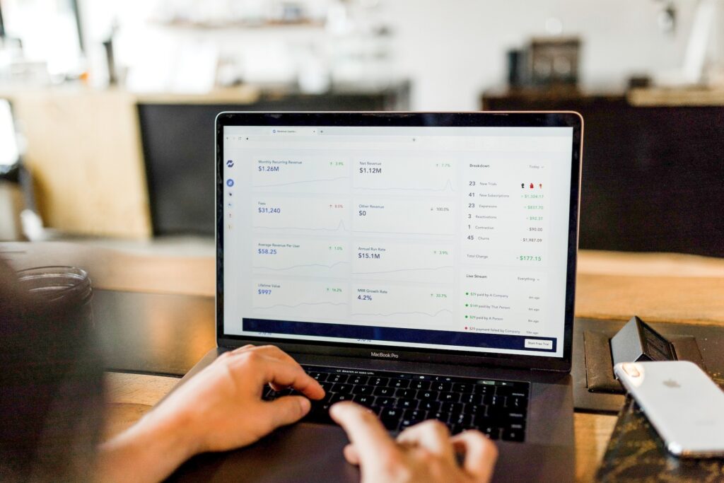 person using macbook reviewing financial information