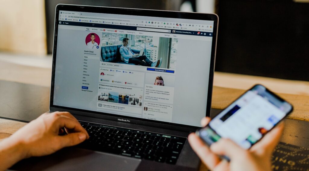 A person working on Facebook on their laptop and mobile phone, representing defamation claims in Ontario.