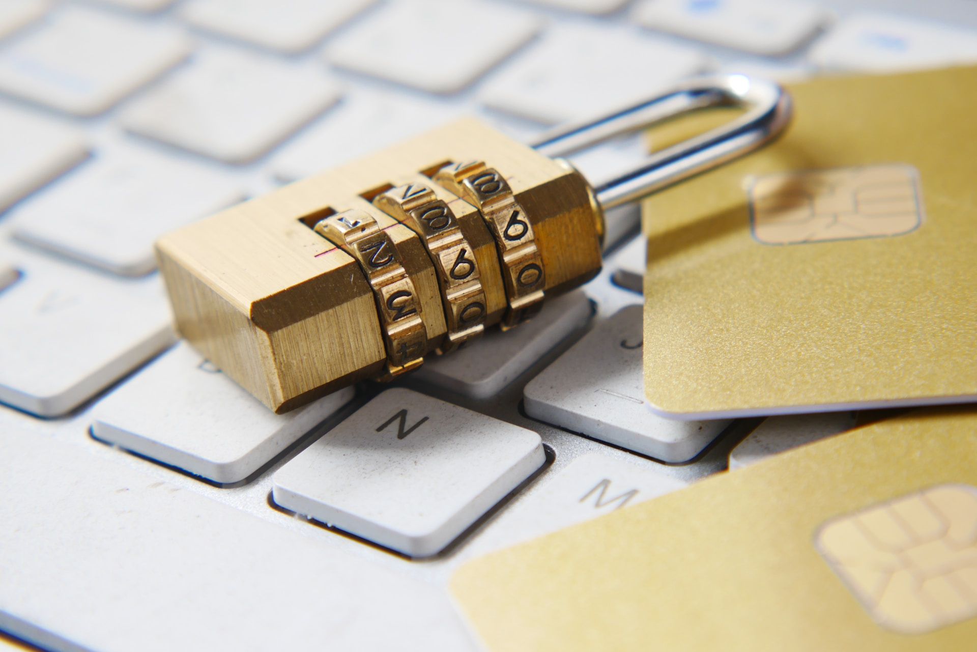 A padlock and two golden credit cards on top of a computer keyboard, representing data scraping and privacy breaches in Canada