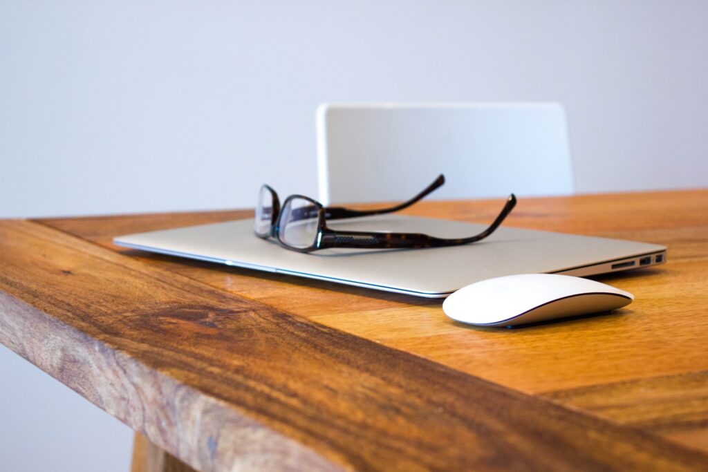 black framed glasses sitting on mac computer