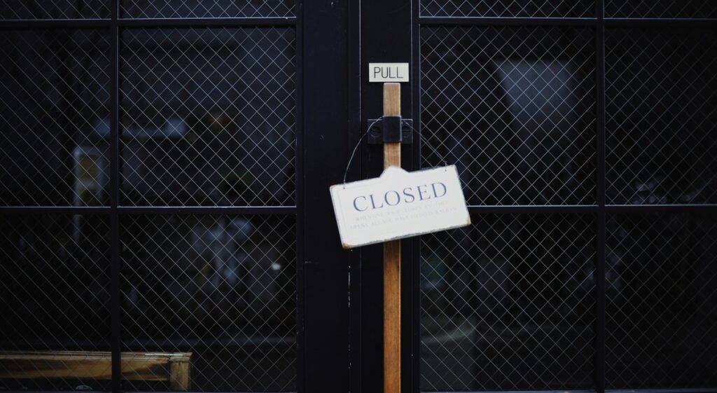 A black industrial mesh gate that is locked with a white 
