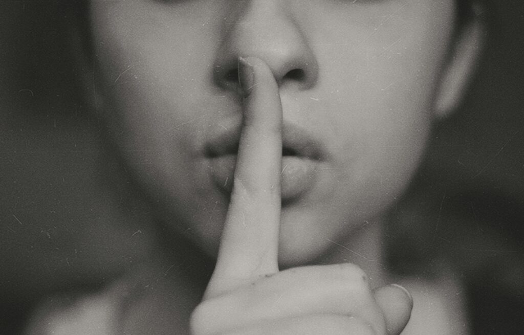 finger over mouth representing a review of breach of confidence and what the law perceives as insider trading