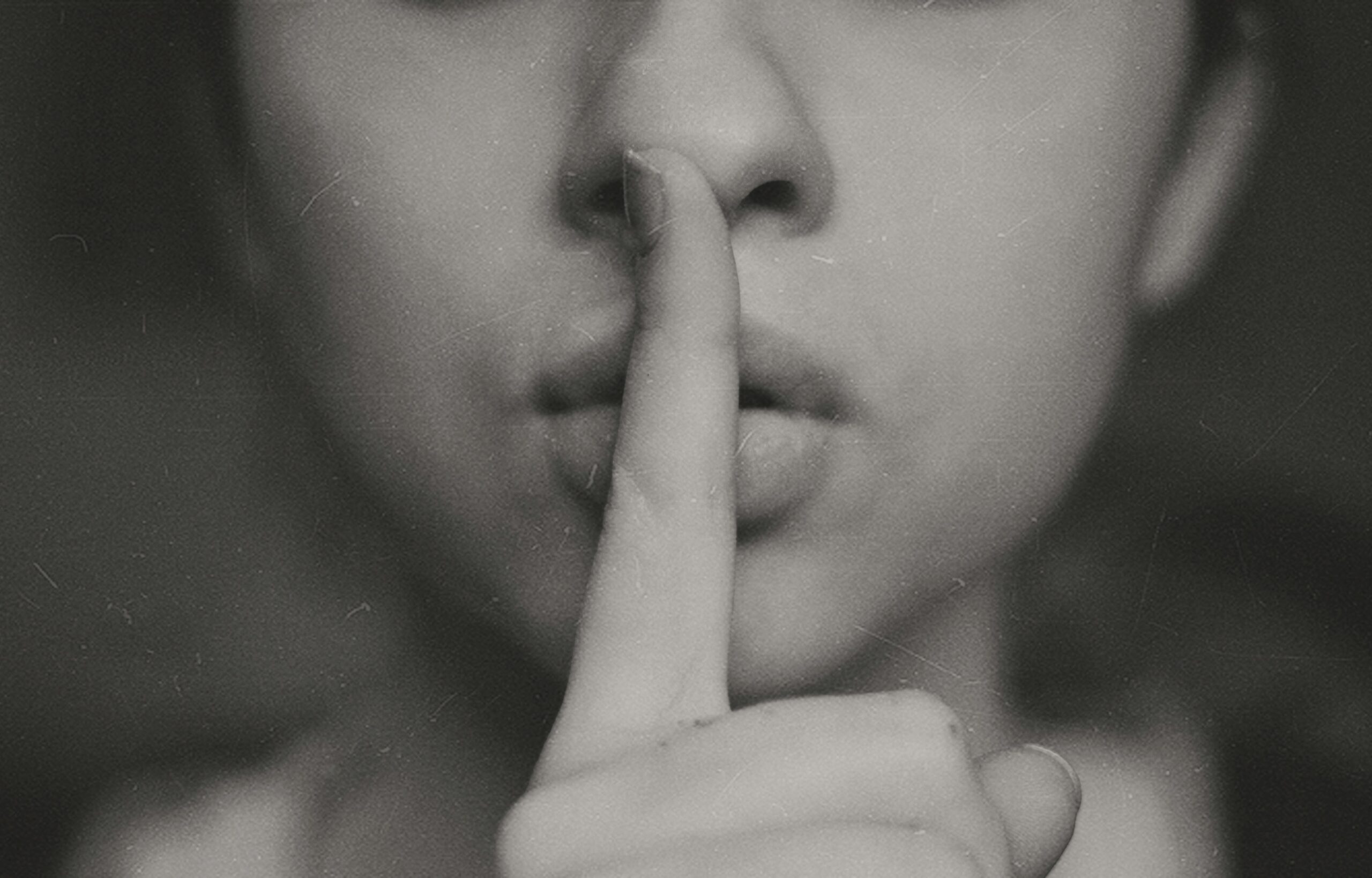 finger over mouth representing a review of breach of confidence and what the law perceives as insider trading
