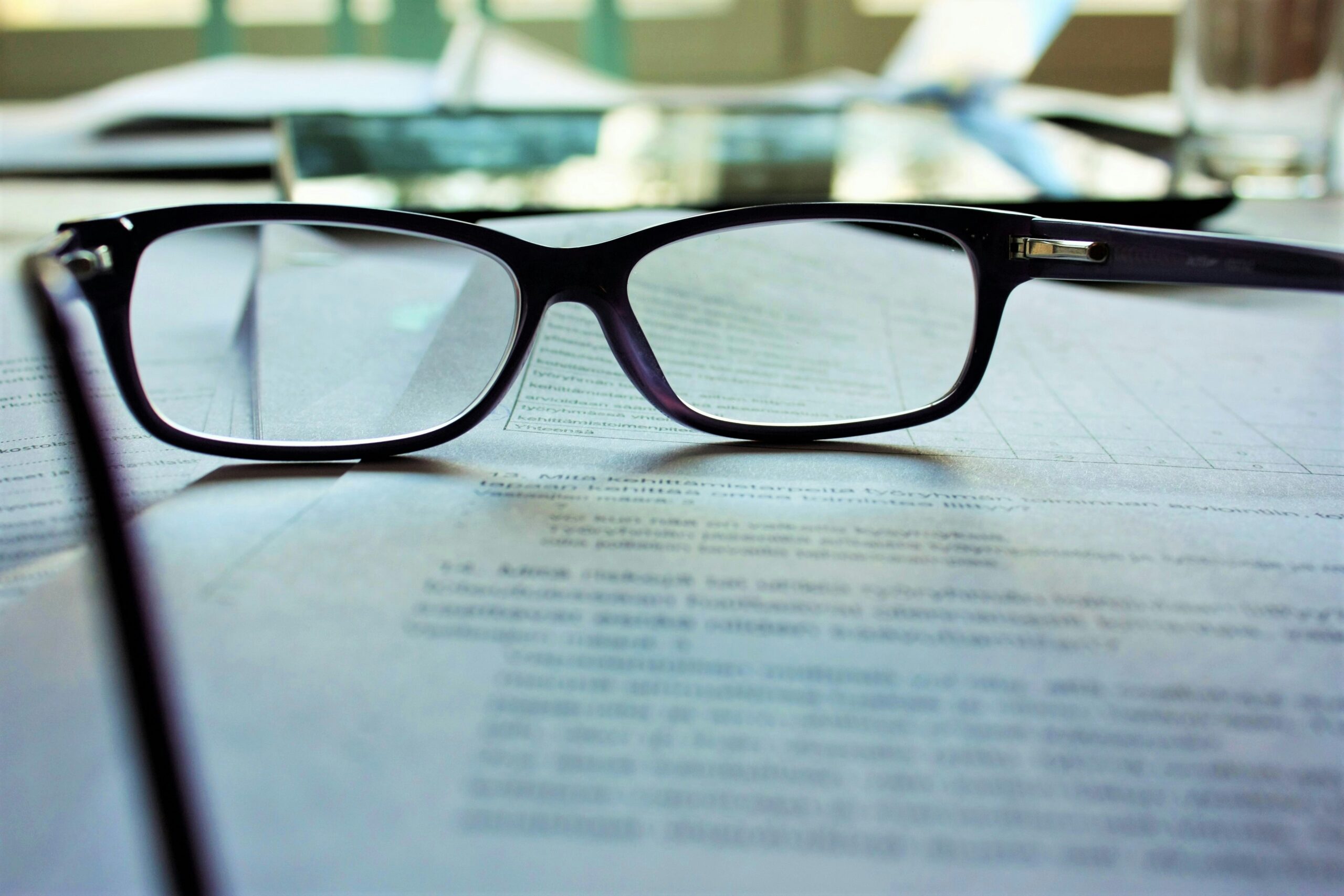 Reading glasses on a document representing abuse of process in litigation