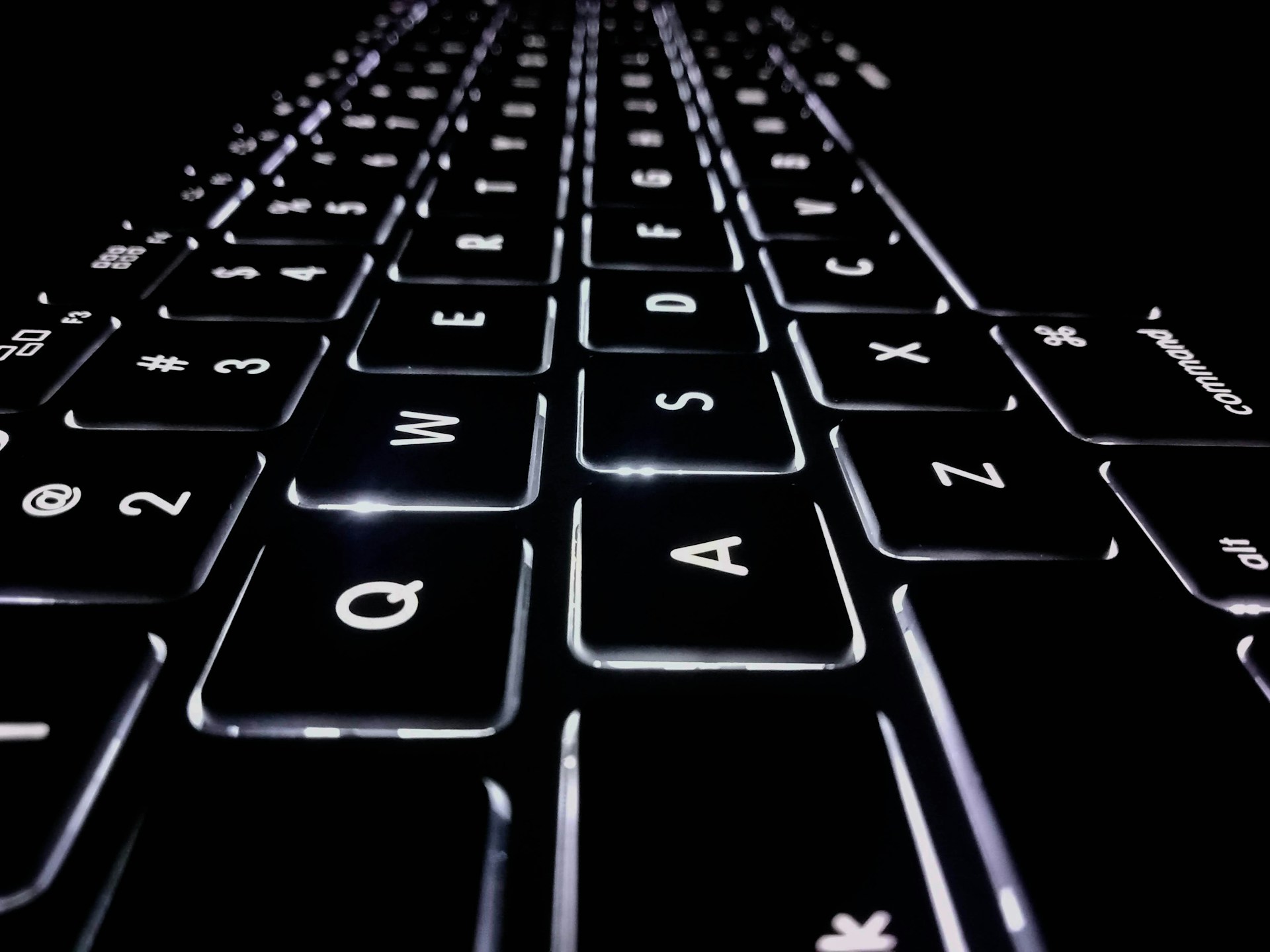 A close-up, side-angle of a black back-lit keyboard, representing Norwich Orders and defamation.