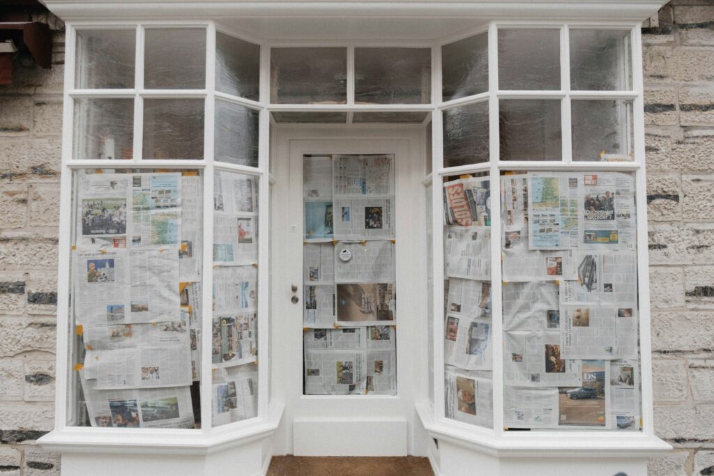 The entrance of a closed and bankrupt business, with newspapers covering the door and windows, representing bankrupt debtors.