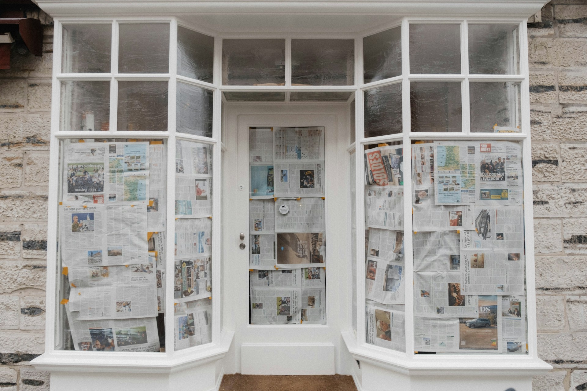 The entrance of a closed and bankrupt business, with newspapers covering the door and windows, representing bankrupt debtors.