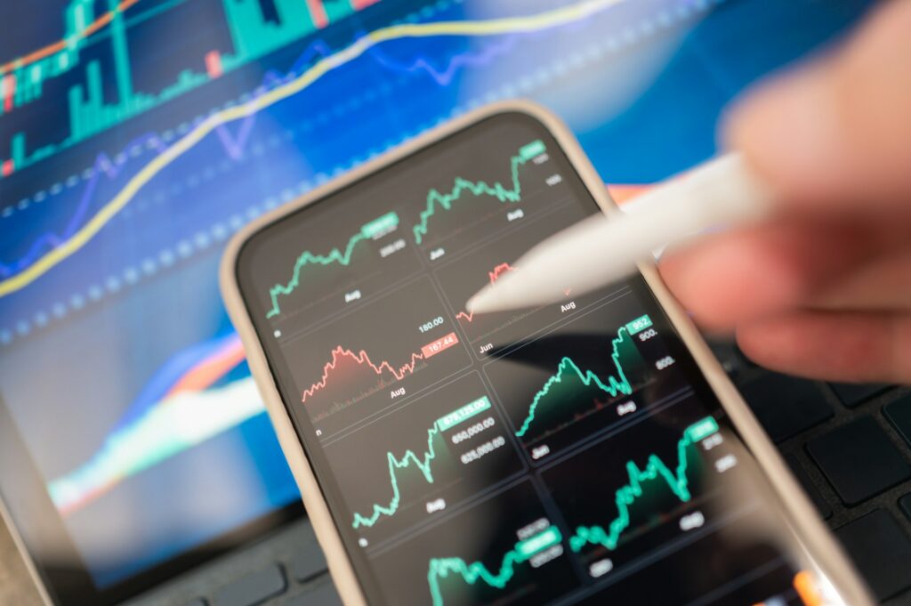 A computer screen and smartphone displaying financial forecasts, representing negligent misrepresentation claims based on financial advice and financial forecasts in Ontario