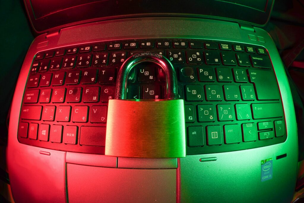 A gold padlock on a laptop keyboard that is lit up red on one side and green on the other, representing electronic funds transfer fraud.