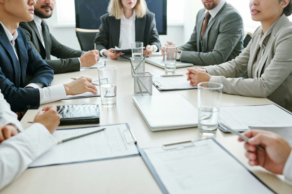 A group of professionals sitting at a table conducting a meeting depicting a shareholders meeting