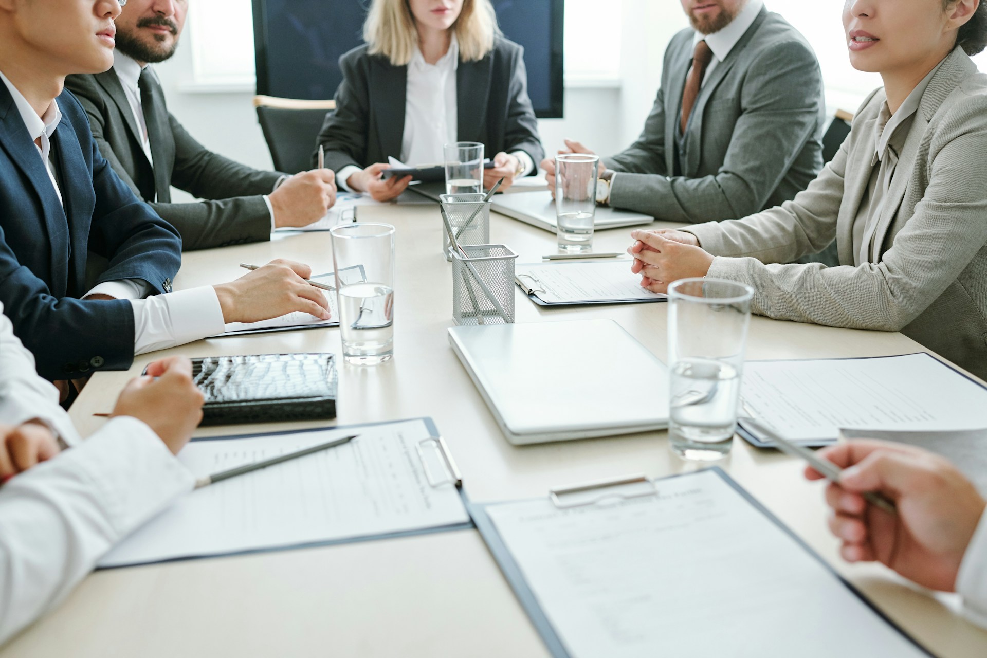 A group of professionals sitting at a table conducting a meeting depicting a shareholders meeting