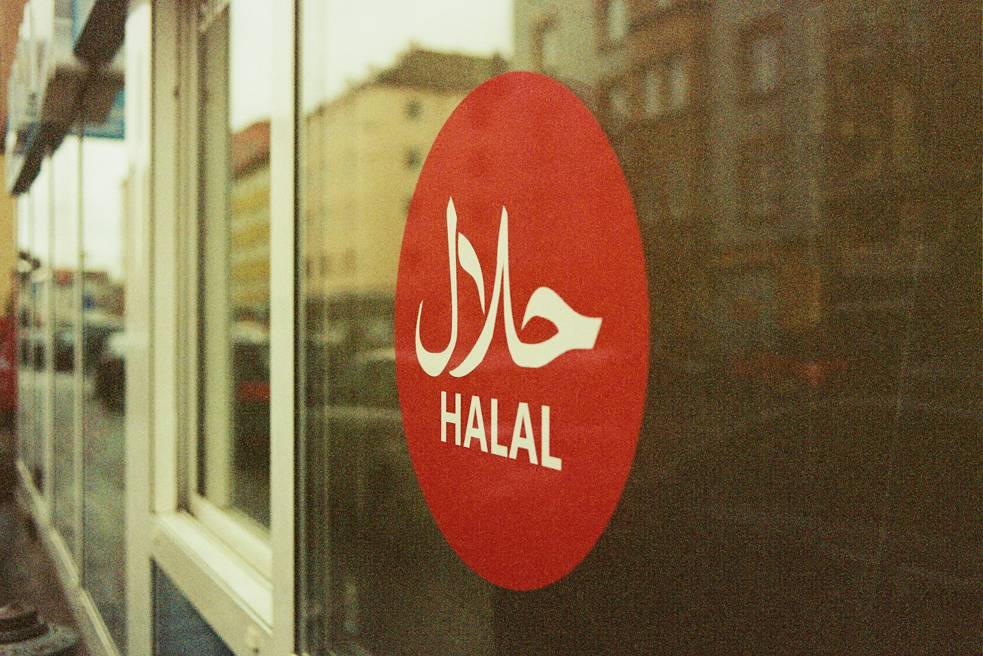 A red Halal sticker on a storefront window, representing the case of Islamic Food and Nutrition Council of Canada v. Islamic Food and Nutrition Council of America and voting rights of non-profit stakeholders in Ontario