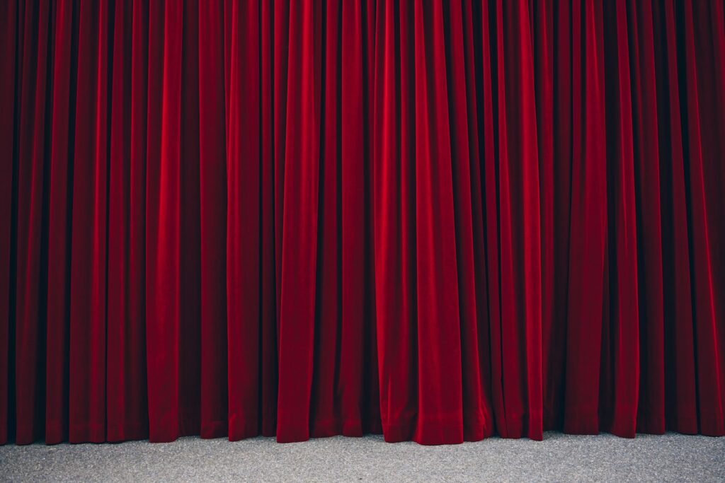 Closed red velvet curtains, representing shell companies and hidden assets.